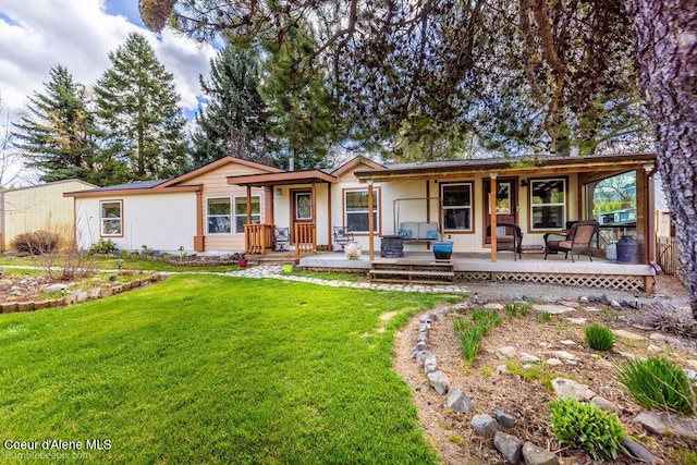 rear view of property with a yard and covered porch