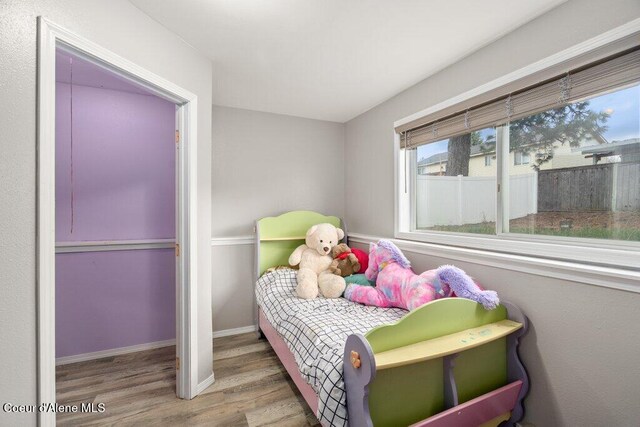 bedroom featuring wood finished floors and baseboards