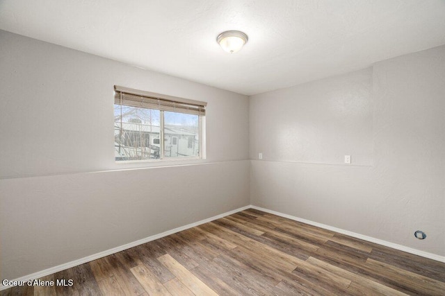 empty room featuring baseboards and wood finished floors