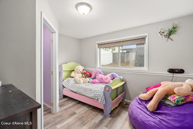 bedroom featuring baseboards and wood finished floors