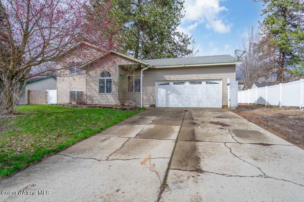 6451 W Tombstone St, Rathdrum, ID 83858 - single story home featuring concrete driveway, a garage, fence, and a front lawn