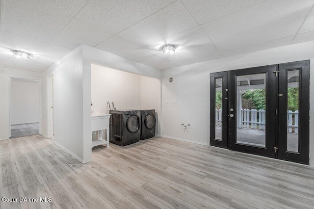 clothes washing area featuring washing machine and clothes dryer, wood finished floors, baseboards, and laundry area