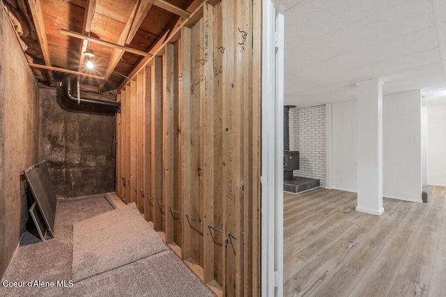 below grade area with a wood stove and wood finished floors