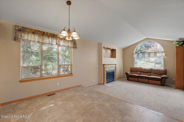 living area featuring a glass covered fireplace, an inviting chandelier, carpet floors, visible vents, and lofted ceiling