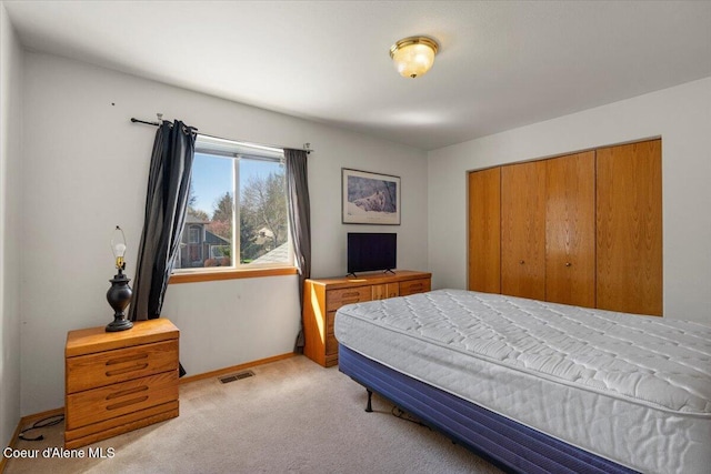 bedroom with a closet, baseboards, carpet, and visible vents
