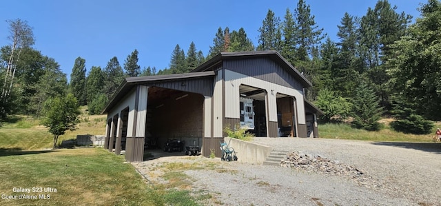 exterior space with a yard, a detached garage, and an outbuilding