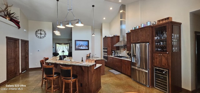 kitchen with stainless steel fridge with ice dispenser, an island with sink, a high ceiling, wine cooler, and hanging light fixtures