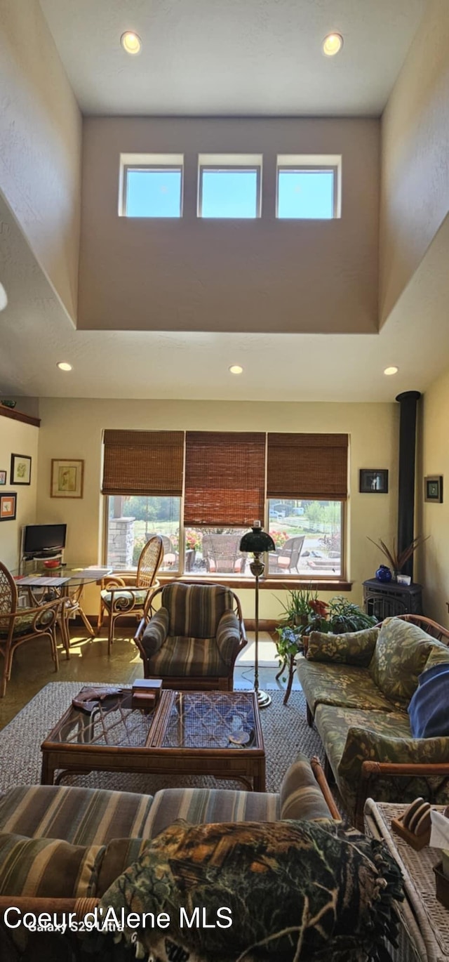 living room with recessed lighting, plenty of natural light, and a high ceiling