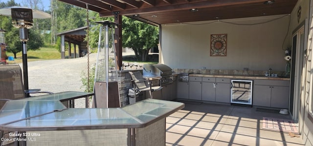 view of patio / terrace with outdoor dining space, grilling area, area for grilling, wine cooler, and a sink