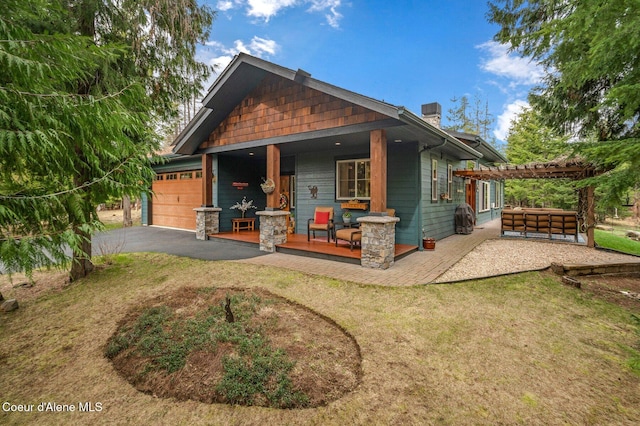 137 Bitterroot Pass, Sagle, ID 83860 - rear view of house with a pergola, a yard, an attached garage, covered porch, and aphalt driveway