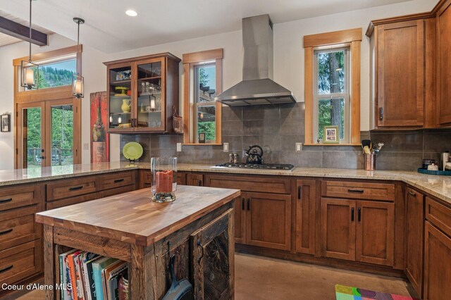 137 Bitterroot Pass, Sagle, ID 83860 - kitchen with stainless steel gas cooktop, butcher block counters, wall chimney exhaust hood, and backsplash