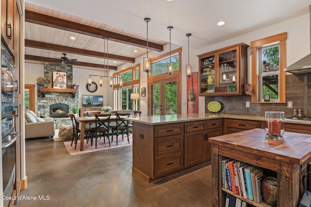 137 Bitterroot Pass, Sagle, ID 83860 - kitchen featuring concrete floors, wall chimney range hood, butcher block counters, decorative backsplash, and stainless steel appliances