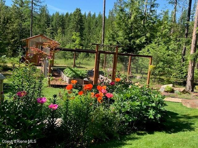 137 Bitterroot Pass, Sagle, ID 83860 - view of yard with an outbuilding, a garden, a wooded view, and a storage unit