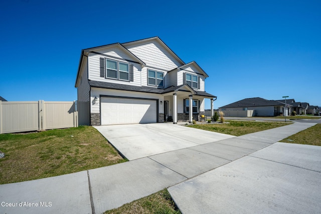 4209 May Ella Lp, Post Falls, ID 83854 - craftsman-style home featuring stone siding, a front lawn, fence, and a garage