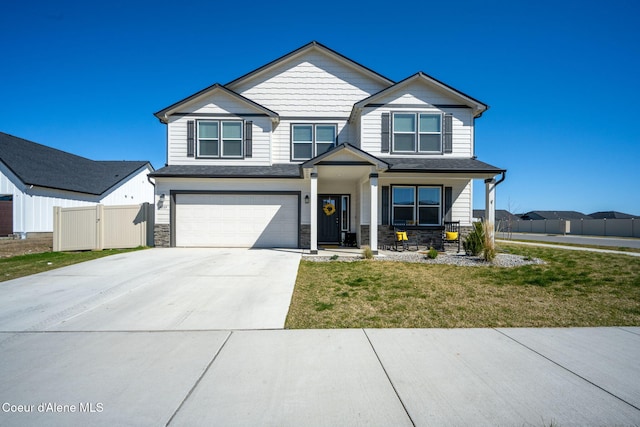 4209 May Ella Lp, Post Falls, ID 83854 - craftsman-style house featuring concrete driveway, an attached garage, fence, and stone siding