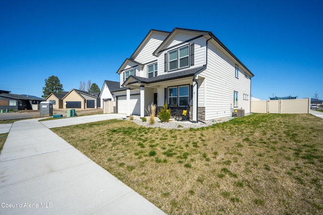 4209 May Ella Lp, Post Falls, ID 83854 - view of front of home with driveway, stone siding, a front yard, and fence
