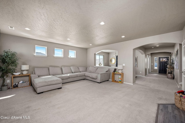 4209 May Ella Lp, Post Falls, ID 83854 - living room featuring arched walkways, a textured ceiling, carpet, and visible vents