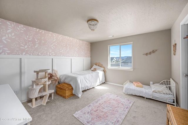 4209 May Ella Lp, Post Falls, ID 83854 - carpeted bedroom featuring wallpapered walls, a wainscoted wall, and a textured ceiling