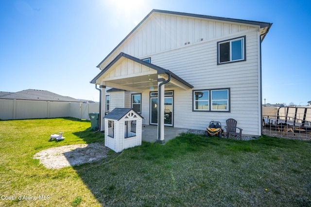 4209 May Ella Lp, Post Falls, ID 83854 - rear view of house with board and batten siding, a patio area, a fenced backyard, and a yard