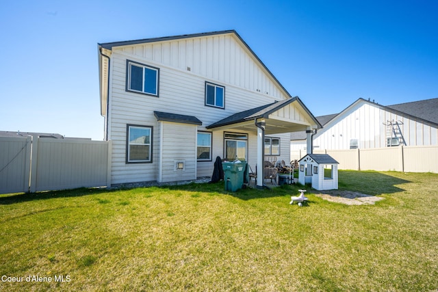4209 May Ella Lp, Post Falls, ID 83854 - back of house with board and batten siding, a yard, and a fenced backyard