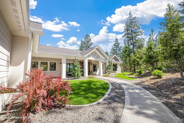 exterior space featuring a front lawn and roof with shingles
