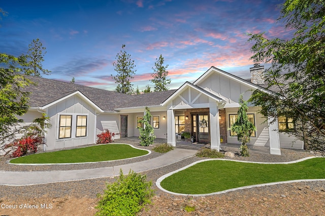 view of front of home with board and batten siding, a front lawn, and a chimney
