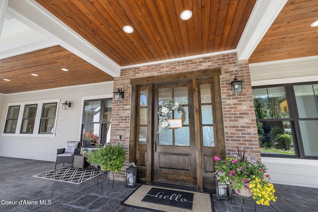 entrance to property with brick siding and a porch