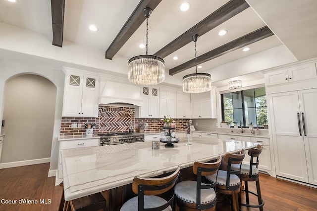 kitchen featuring custom exhaust hood, backsplash, white cabinets, and stove