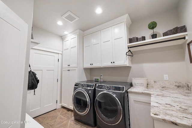 clothes washing area featuring recessed lighting, visible vents, washing machine and clothes dryer, and cabinet space