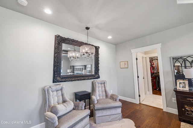 living area featuring a chandelier, recessed lighting, baseboards, and wood finished floors