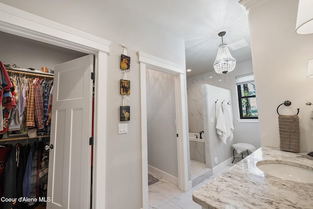 bathroom featuring a shower stall, a spacious closet, marble finish floor, a sink, and baseboards