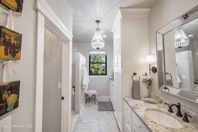 bathroom with baseboards, marble finish floor, a notable chandelier, and vanity
