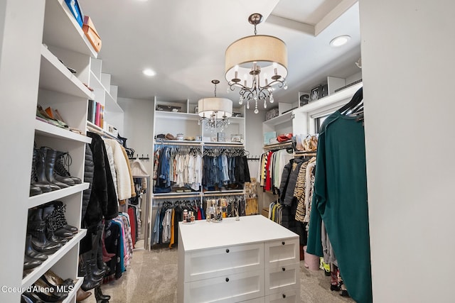 spacious closet with a chandelier and light colored carpet