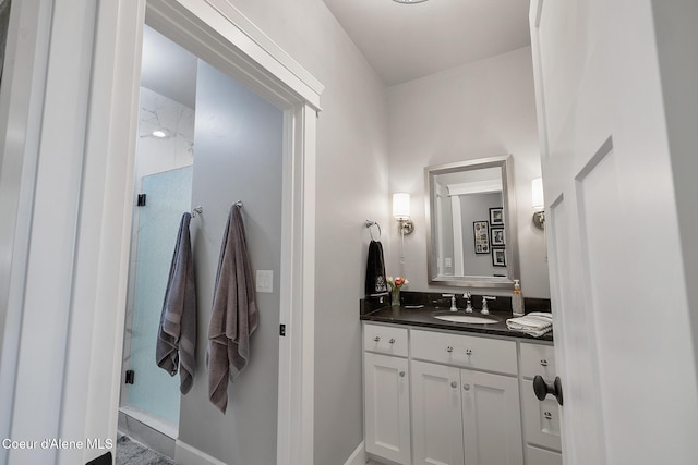 full bathroom featuring a shower, vanity, and baseboards