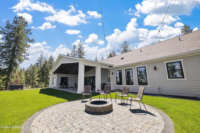 back of house with a fire pit, a patio, and a lawn