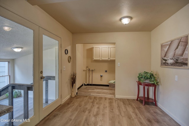1813 N Spokane St, Post Falls, ID 83854 - hallway featuring french doors, baseboards, light wood-type flooring, and a textured ceiling