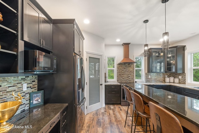 26 Hanaford Rd, Blanchard, ID 83804 - kitchen featuring appliances with stainless steel finishes, wall chimney range hood, tasteful backsplash, light wood finished floors, and recessed lighting