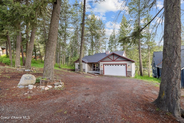 26 Hanaford Rd, Blanchard, ID 83804 - view of front of home with driveway, an attached garage, and stone siding