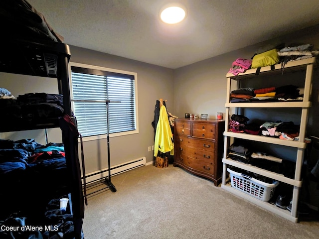 bedroom with a baseboard heating unit and carpet