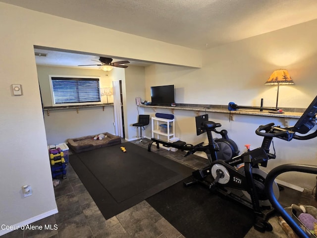 exercise area featuring ceiling fan and baseboards