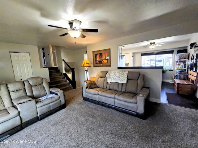 carpeted living area featuring stairway and ceiling fan
