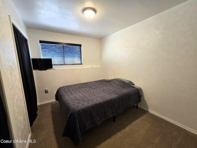 bedroom with a textured wall, baseboards, and carpet flooring