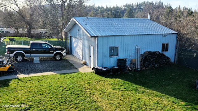 exterior space featuring an outdoor structure, driveway, and fence