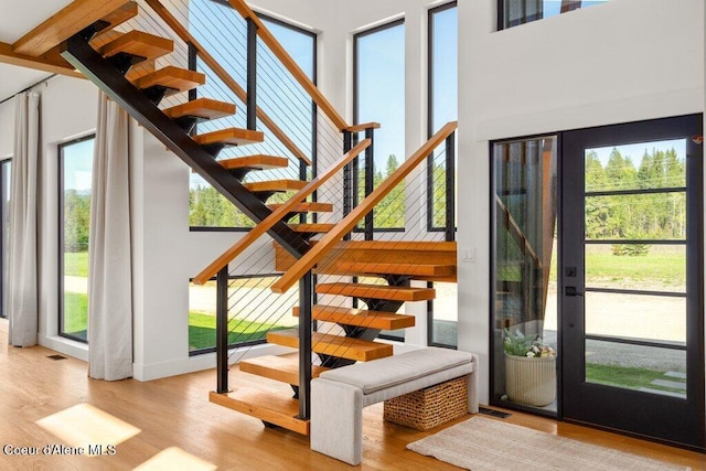 interior space with wood finished floors and a towering ceiling