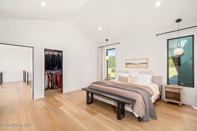 bedroom with recessed lighting, light wood-style flooring, vaulted ceiling, and a spacious closet