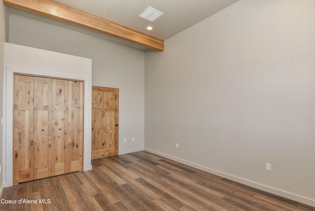 empty room with beam ceiling, visible vents, baseboards, recessed lighting, and wood finished floors