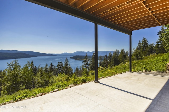view of patio with a water and mountain view