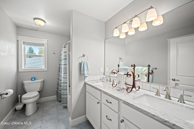 bathroom featuring a sink, baseboards, tile patterned flooring, and toilet