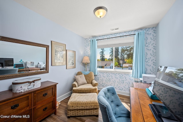 living area with baseboards, wood finished floors, and visible vents