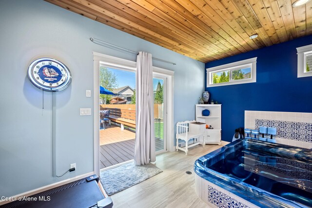bedroom with wooden ceiling, access to exterior, and wood finished floors